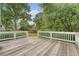 Spacious wooden deck with white railings overlooks the lush backyard and mature trees at 102 Bristol Ln, Goose Creek, SC 29445