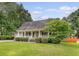 Charming home featuring a covered porch with white railings and meticulously kept landscaping at 102 Bristol Ln, Goose Creek, SC 29445