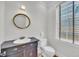 Powder room with traditional sink, antique vanity, and a window with privacy blinds at 103 Fishburne St, Charleston, SC 29403