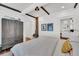 Bedroom with whitewashed walls, wooden floors and a view into bathroom at 103 Fishburne St, Charleston, SC 29403