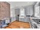 Spacious kitchen boasting gray cabinets, stainless appliances, and a brick accent wall at 103 Fishburne St, Charleston, SC 29403