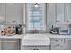 Close-up of kitchen with farmhouse sink, modern appliances, and sleek cabinetry at 103 Fishburne St, Charleston, SC 29403