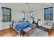 Bright main bedroom with two windows, ceiling fan, and hardwood floors at 103 Fishburne St, Charleston, SC 29403