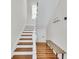 Bright staircase with wooden steps and a white railing leading to upper floors at 103 Fishburne St, Charleston, SC 29403
