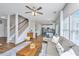 Inviting living room with wood floors, staircase, plush seating, ceiling fan, and seamless flow to the kitchen at 107 Tandil Ct, Summerville, SC 29483