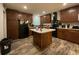 Well-appointed kitchen featuring dark wood cabinets, a central island, and modern black appliances at 110 Kay St, Ridgeville, SC 29472