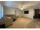 Spacious living room with neutral carpet, ceiling fan, TV, and comfortable sectional couch at 110 Kay St, Ridgeville, SC 29472