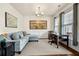Living area with a cozy blue sofa, decorative mirror, and sunlit windows at 110 Ricewood Ln, Moncks Corner, SC 29461