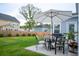 Outdoor patio with table, chairs, umbrella, and grill overlooking the grassy backyard and neighborhood at 1100 Saltwater Cir, Johns Island, SC 29455
