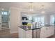 Open-concept kitchen with gray counters, white cabinets, stainless appliances, and an adjacent living area at 1100 Saltwater Cir, Johns Island, SC 29455
