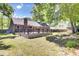 Backyard view showcasing a spacious wooden deck, lush green lawn, and mature trees, perfect for entertaining at 113 Dove Ln, Summerville, SC 29485