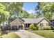 Charming brick home featuring a two-car garage, manicured lawn, and mature trees offering curb appeal at 113 Dove Ln, Summerville, SC 29485