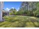Expansive backyard with lush green grass, mature trees, and an outdoor seating area with a fire pit at 1166 Turkey Trot Dr, Johns Island, SC 29455