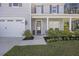 Inviting front porch with a decorative wreath, potted flowers, and a freshly manicured lawn at 1166 Turkey Trot Dr, Johns Island, SC 29455