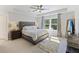 Serene main bedroom featuring a tray ceiling, large window, neutral tones, and stylish furniture at 1166 Turkey Trot Dr, Johns Island, SC 29455