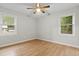 Well-lit empty bedroom with a ceiling fan, hardwood floors, and two windows at 120 Lisa Dr, Summerville, SC 29485