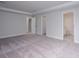 Spacious bedroom with neutral carpeting, crown molding, and doorways to adjoining rooms at 121 Royal Cainhoy Way, Huger, SC 29450