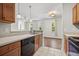 View of kitchen with wooden cabinetry, tile backsplash and view into living room with hardwood floors at 1225 Blakeway St # 1401, Charleston, SC 29492