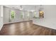 Bright living room with wood floors, large windows with shades, and an open kitchen area at 1225 Blakeway St # 1401, Charleston, SC 29492