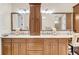 Bathroom featuring double sinks with granite countertops, wood cabinetry, and decorative mirrors at 1305 Old Rice Mill Rd, Moncks Corner, SC 29461