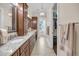Bathroom featuring double sinks with granite countertops, wood cabinetry, and access to a walk-in closet at 1305 Old Rice Mill Rd, Moncks Corner, SC 29461