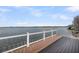 A modern wooden deck with glass railings provides panoramic water views and is perfect for outdoor living at 1305 Old Rice Mill Rd, Moncks Corner, SC 29461
