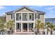 Charming home with a covered porch supported by columns and complemented by palm trees and a well-manicured lawn at 1305 Old Rice Mill Rd, Moncks Corner, SC 29461