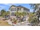 Stunning three-story home featuring a beautifully landscaped front yard and a classic exterior with elegant architectural details at 1305 Old Rice Mill Rd, Moncks Corner, SC 29461