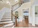 Elegant foyer featuring a wood staircase with decorative iron railing and views into the living room at 1305 Old Rice Mill Rd, Moncks Corner, SC 29461