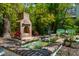 Landscaped backyard featuring a brick fireplace, water feature with sculptures, and lush greenery for outdoor enjoyment at 135 Beaufain St, Charleston, SC 29401