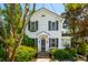 Charming two-story home with black shutters, beautiful landscaping, and a brick walkway leading to the front door at 135 Beaufain St, Charleston, SC 29401
