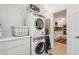 Well-lit laundry room features a stacked washer/dryer unit and ample cabinet space for storage at 135 Beaufain St, Charleston, SC 29401