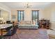 Comfortable living room area with a sofa, windows with wooden blinds, chandelier, and a view into the kitchen at 135 Beaufain St, Charleston, SC 29401