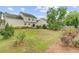Large backyard with a deck and rear view of home showcasing mature trees, landscaping and lawn at 137 Cotillion Cres, Summerville, SC 29483