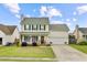 Attractive two-story house featuring a quaint front porch, attached garage, and lovely lawn with flowerbeds at 137 Cotillion Cres, Summerville, SC 29483