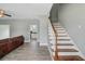 Bright living room featuring wood-look tile floors, staircase, and view into the modern kitchen and dining area at 137 Cotillion Cres, Summerville, SC 29483