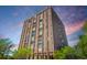 Striking exterior elevation of a high-rise apartment building with brick facade, set against a dramatic sky at 14 Lockwood Dr # 9K, Charleston, SC 29401