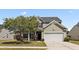 Charming home featuring a manicured lawn, mature tree, an attached two-car garage, and a welcoming covered entryway at 144 Marinella Dr, Goose Creek, SC 29445