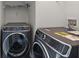 Modern laundry room with front loading washer and dryer on a wire rack shelf, ideal for efficient laundry care at 144 Marinella Dr, Goose Creek, SC 29445