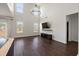 Spacious living room boasts soaring ceilings, large windows, modern chandelier, dark wood floors and media center at 144 Marinella Dr, Goose Creek, SC 29445