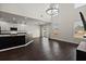 Open-concept living and kitchen area featuring soaring ceilings, hardwood floors, stainless appliances, and island seating at 144 Marinella Dr, Goose Creek, SC 29445