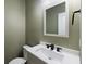 Modern powder room features white vanity with black hardware, stylish sink and fixtures at 144 Marinella Dr, Goose Creek, SC 29445