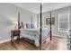 Bedroom featuring a four poster bed with wood floors, bedside table and side windows at 1472 Longspur Dr, Mount Pleasant, SC 29466