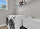 Bright laundry room featuring a utility sink, washer, dryer and shelving for supplies at 1472 Longspur Dr, Mount Pleasant, SC 29466