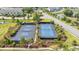 Aerial view of community tennis courts with landscaping and nearby pond in a residential neighborhood at 1472 Longspur Dr, Mount Pleasant, SC 29466