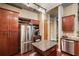 Modern kitchen featuring stainless steel appliances, dark wood cabinets, and a convenient island, with wine storage above fridge at 150 Bee St # 507, Charleston, SC 29401