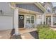 A welcoming front porch with rocking chairs, lush landscaping, and a decorative wreath on the front door at 152 Kirkland St, Goose Creek, SC 29445