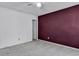 Spacious bedroom with neutral carpet, a burgundy accent wall and access to an adjacent room at 153 Corsair St, Summerville, SC 29483
