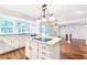 Open kitchen design featuring white cabinets, island cooktop, and view into living room with fireplace at 1541 Diamond Blvd, Mount Pleasant, SC 29466