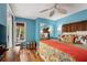 Bright bedroom featuring wooden floors, ceiling fan, sliding closet, and colorfully decorated bed at 1619 Live Oak Park, Johns Island, SC 29455